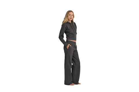 woman stands sideways wearing a matching set of straight-cut  loungewear sweatpants