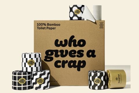 Who Gives A Crap Premium Bamboo Toilet Paper stacked next to box in black and white packaaging