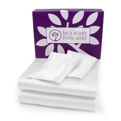 white silk sheets folded in front of purple box
