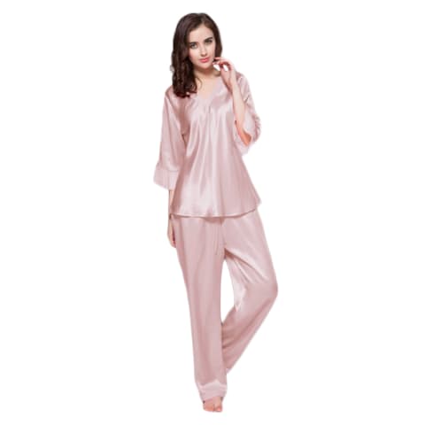 Brunette woman wearing pink long sleeved silk pajama top and pants