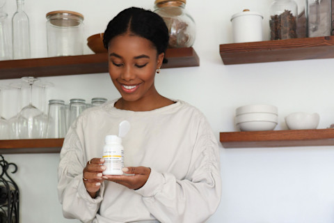 Woman holding a bottle of Integrative Therapeutics Cortisol Manager
