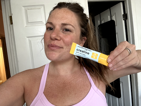 author holding creatine packet in hand