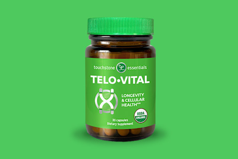 A bottle of Touchstone Essentials TELO-VITAL dietary supplement stands centered against a solid green background. The amber glass bottle has a bright green ridged cap and a green label. The label features the brand logo, product name "TELO-VITAL," a DNA helix-like graphic, and the description "Longevity & Cellular Health**." It also indicates "USDA ORGANIC," "30 capsules," and "Dietary Supplement."