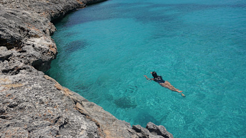 woman swimming in crystal blue waters woman swimming in crystal blue waters