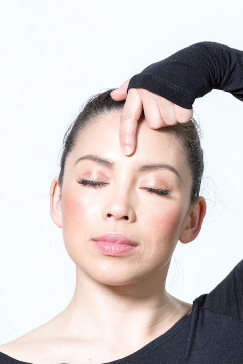 woman massaging third eye for acupressure woman massaging third eye for acupressure