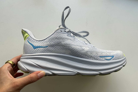 hoka clifton 9 sneaker held up by editor's hand