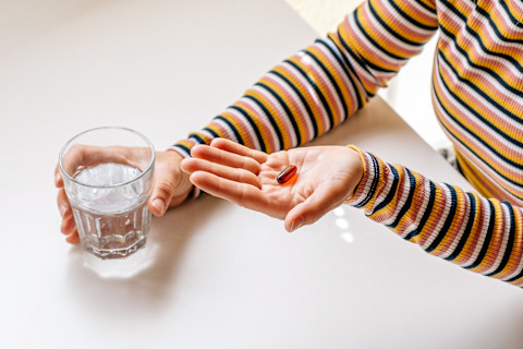 Unrecognizable Woman Taking a Supplement with a Glass of Water Unrecognizable Woman Taking a Supplement with a Glass of Water