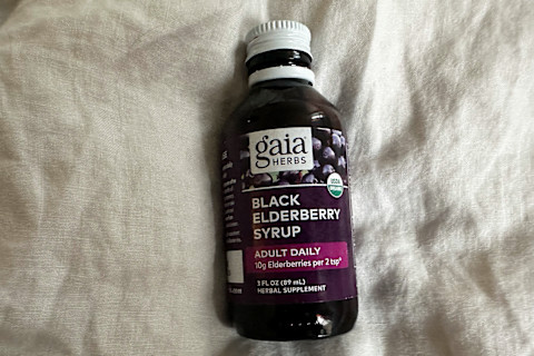 Gaia Herbs Black Elderberry syrup bottle on gray cloth background Gaia Herbs Black Elderberry syrup bottle on gray cloth background