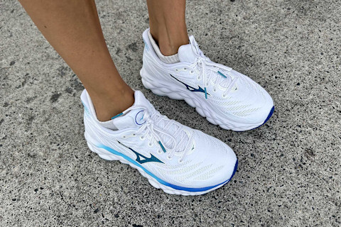 writer's feet wearing the mizuno wave sneakers on pavement
