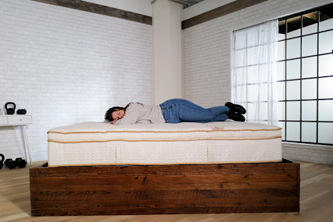 Saatva Latex Hybrid Stomach Sleeper laying on bed testing