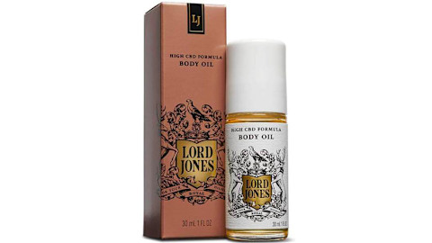 Lord Jones body oil in glass bottle next to red box