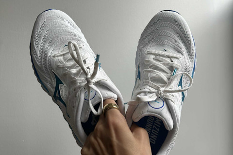 editor's hand holding the mizuno wave shoes