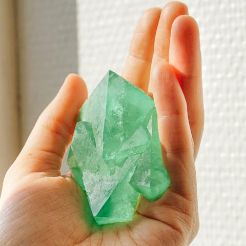 Woman Holding Green Gemstone