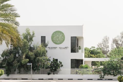wellness center with green logo surrounded by trees