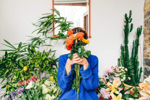 Florist Holding a Bouquet of Flowers In Front Of Her Face