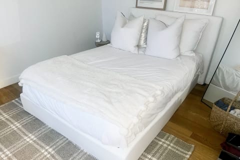 Plushbeds Organic Latex Mattress Review Tester full made bed with four pillows and headboard