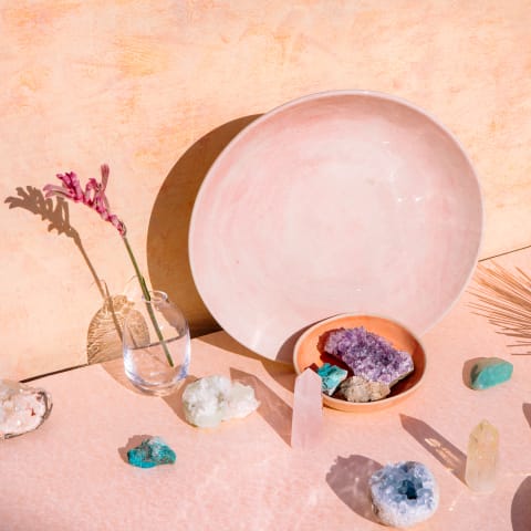 Bohemian chic decor style with collection of beautiful crystals, gemstones and objects on pale pink