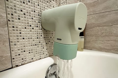 Canopy Bath Tub Filter installed on bath tub spout with water coming out