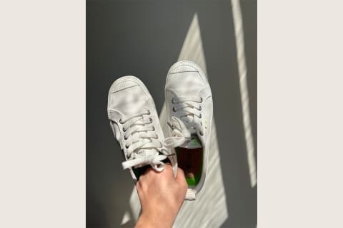 hand holding white sneakers