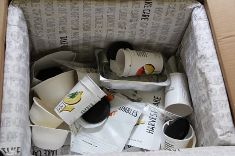 Leftover waste from Daily Harvest box including recyclable cups, aluminum pans, 