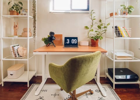 clean desk with two bookcases on either side and a green swivel chair