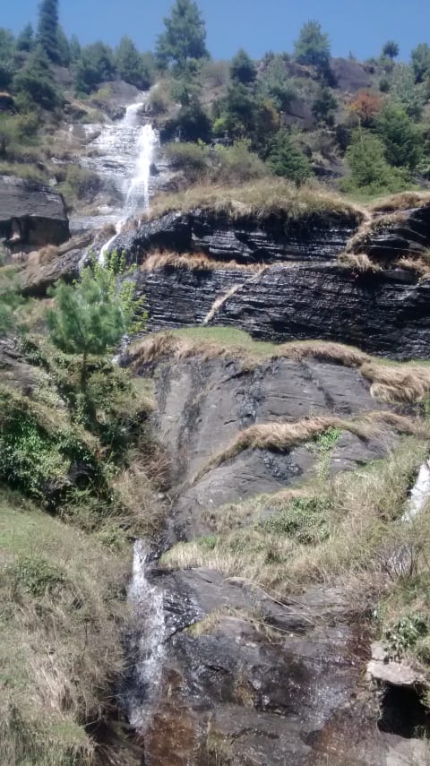 tall waterfall against tree-lined landscape