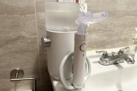 proclaim oral health system on white sink countertop next to faucet