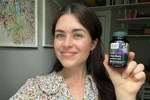 Author (tester) in room holding bottle of gaia herb vitex supplement up to camera in right hand