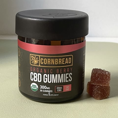 Best CBD Gummies for Sleep Cornbread Hemp Organic Gummies on green background with stack of gummies