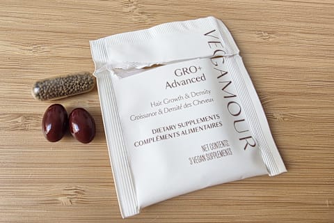 Vegamour GRO+ Advanced Hair Growth & Density Supplements opened package with three capsules next to it