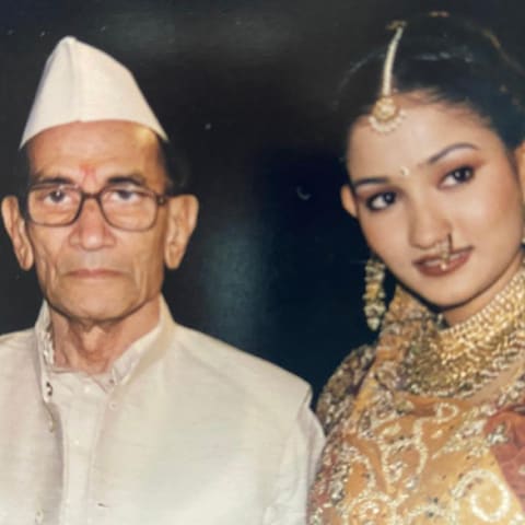 Indian woman standing next to her grandfather