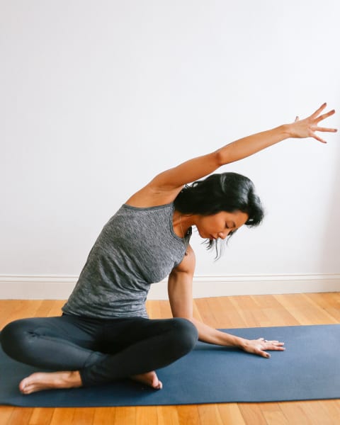 Curly girl doing her morning yoga stretch in a bright and cozy