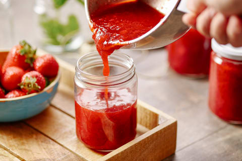 Hand Pouring Jam From Pan In Can