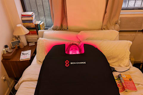 Bon Charge red light blanket on bed with person's face