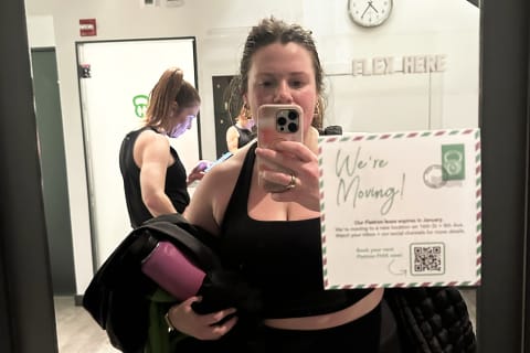 Author taking selfie in mirror after workout class to show sweat along hairline