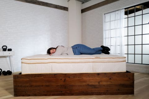 Saatva Latex Hybrid Stomach Sleeper laying on bed testing