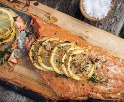 salmon on wood board with lemon on top