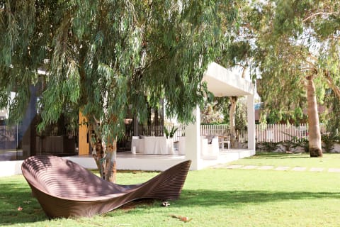white awning surrounded by grass and an oversized lounge chair