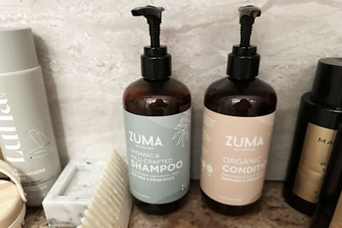 Zuma shampoo & conditioner bottle in shower on shelf