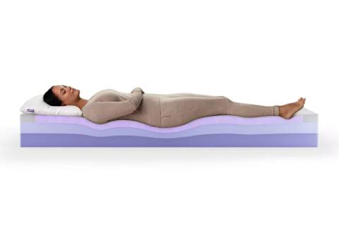 purple mattress image from company website with woman laying on bed (showing layers)