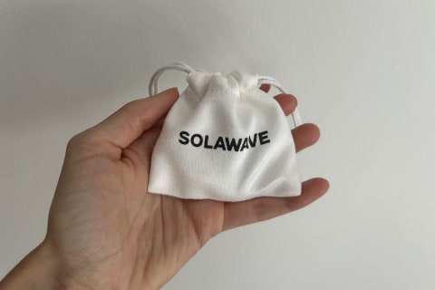 hand holding solawave mini in travel pouch