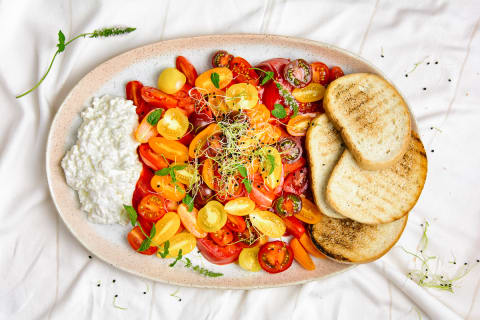 ight brunch with colorful cherry tomatoes, toast, qatiq and cottage cheese