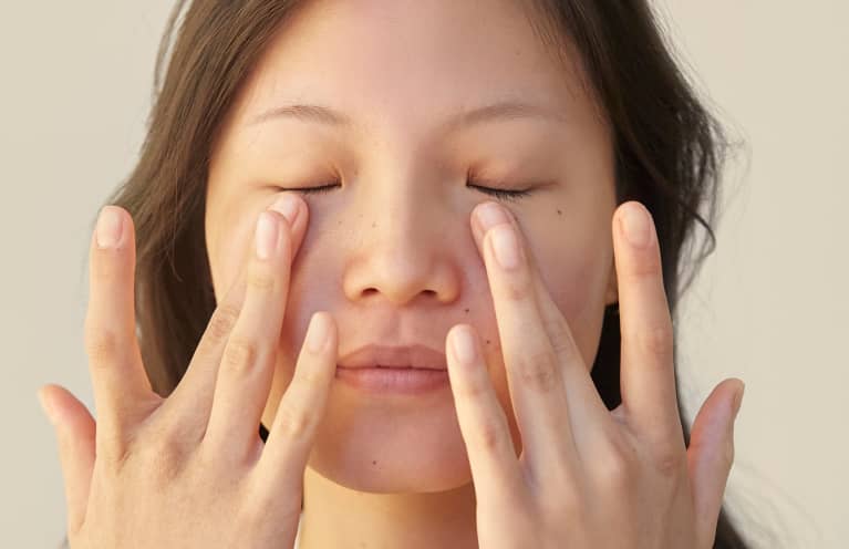 asian woman patting under eye area