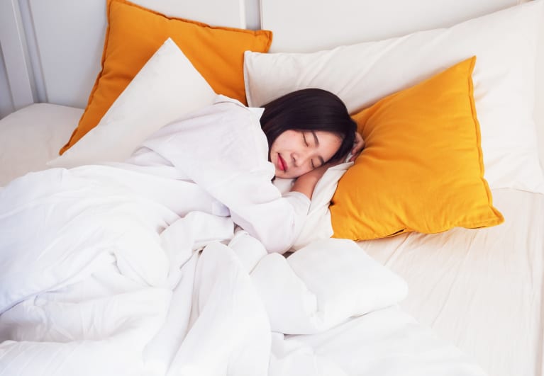 Woman Sleeping Against Pillows