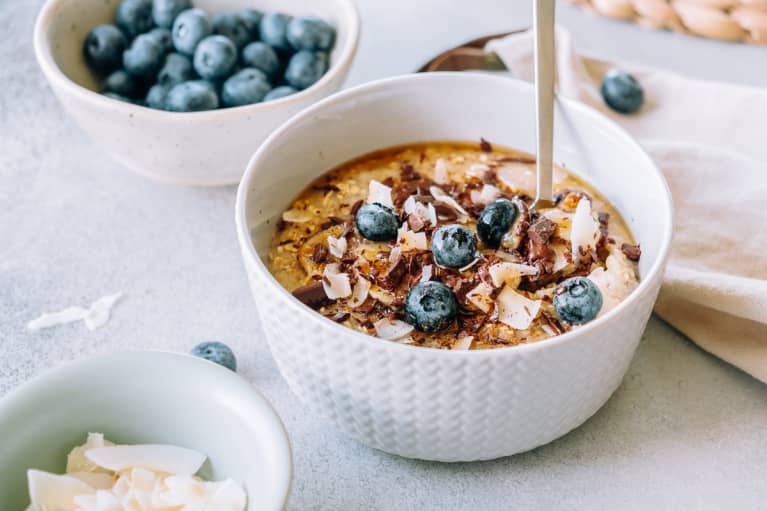 Porridge Topped With Caramelized Banana, Chocolate, Shredded Coconut And Blueberries