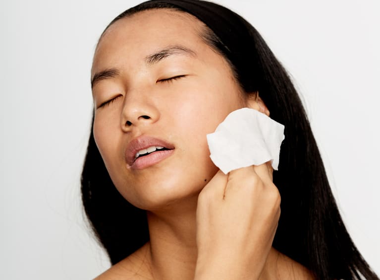 Asian woman washing face with a cloth