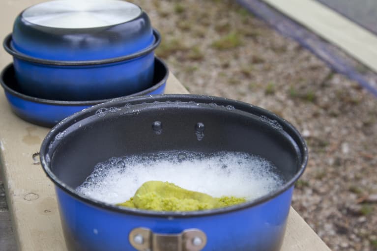 blue pan soaking in water with sponge outdoors