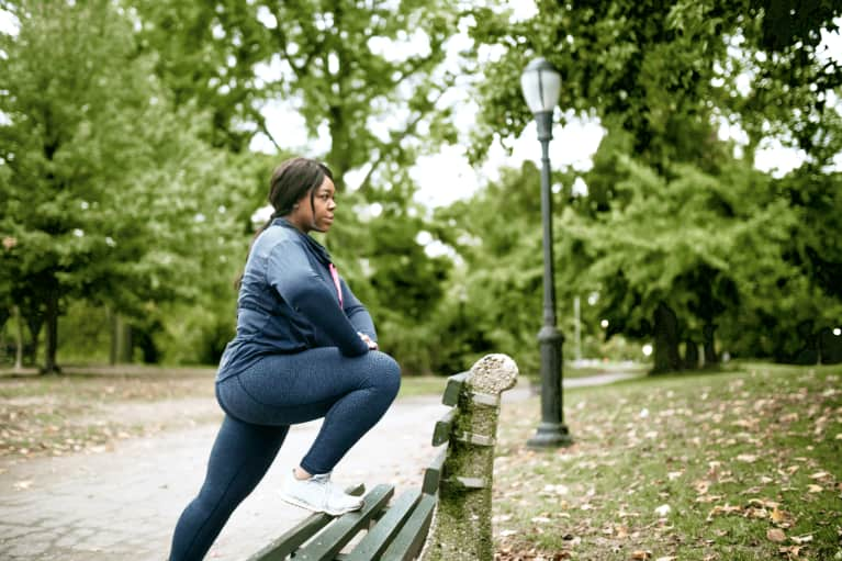 black woman stretching on a bench for her exercise