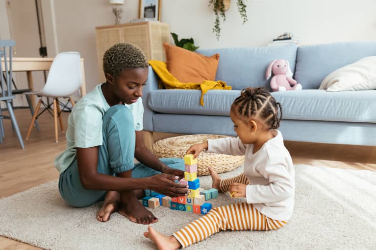 black mother playing with her young daughter using blocks black mother playing with her young daughter using blocks
