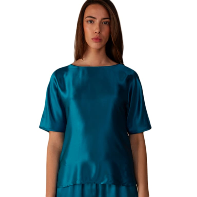 Woman wearing teal silk short sleeve pajama top